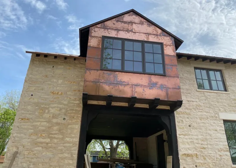 Copper metal panel facade on a stone building for Roof Repair in Columbine